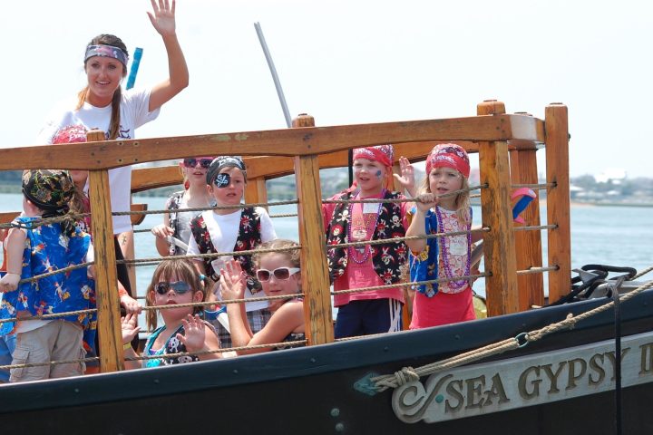 A group waving at the camera from a boat